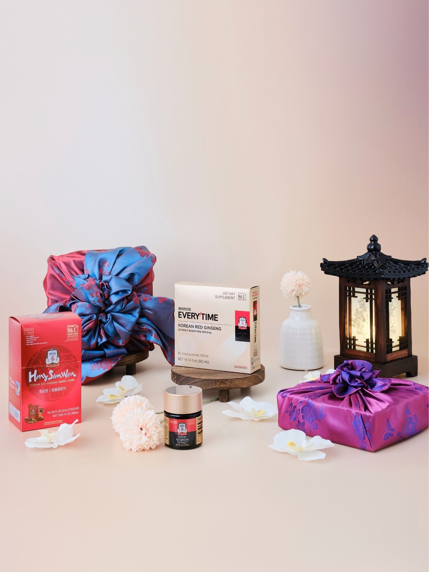 Lunar New Year Korean red ginseng immune gift set featuring Everytime 2000mg sticks, Hong Sam Won, and 120g extract jar wrapped in traditional Korean bojagi with flowers and lantern